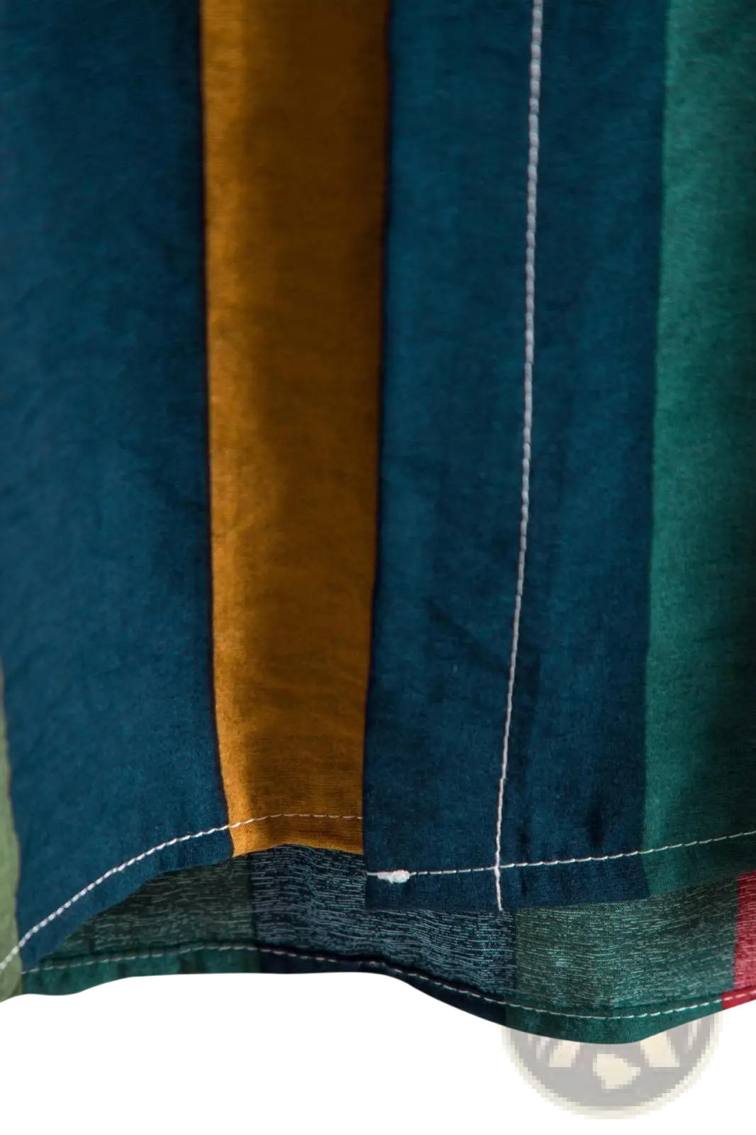 A close-up of a striped short sleeve button up shirt with deep teal mustard yellow and forest green vertical stripes and white stitching