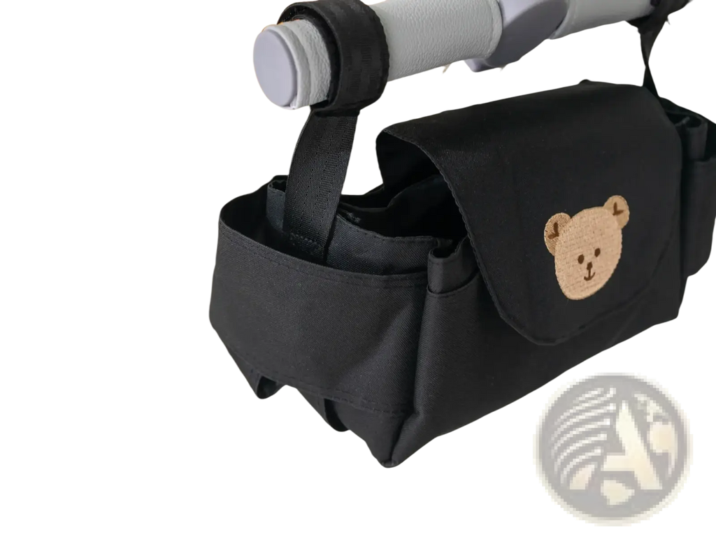 Black fabric stroller organizer bag featuring a beige embroidered bear face design for convenient storage
