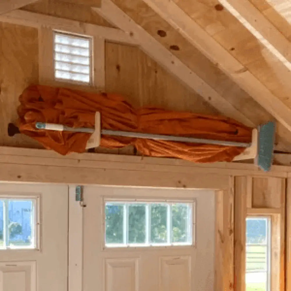 Stud mounted wood and pipe shed storage hooks with orange fabric canopy mounted on metal pole and wooden supports