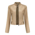 Beige faux leather moto jacket with silver rivets on shoulders and front zipper closure for edgy style