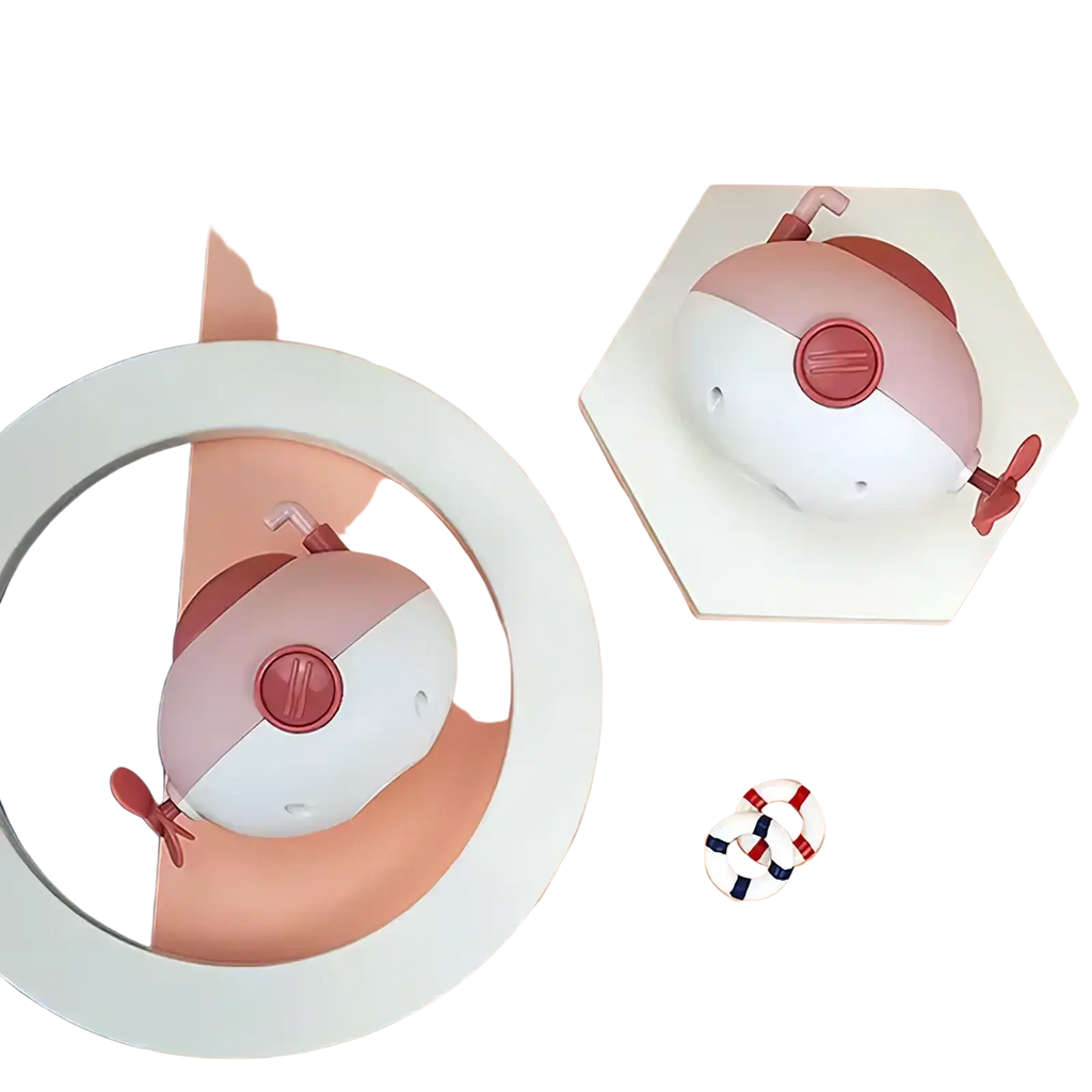 Submarine baby bath toy in pink and white with red accents featuring a central button and small propeller appendages