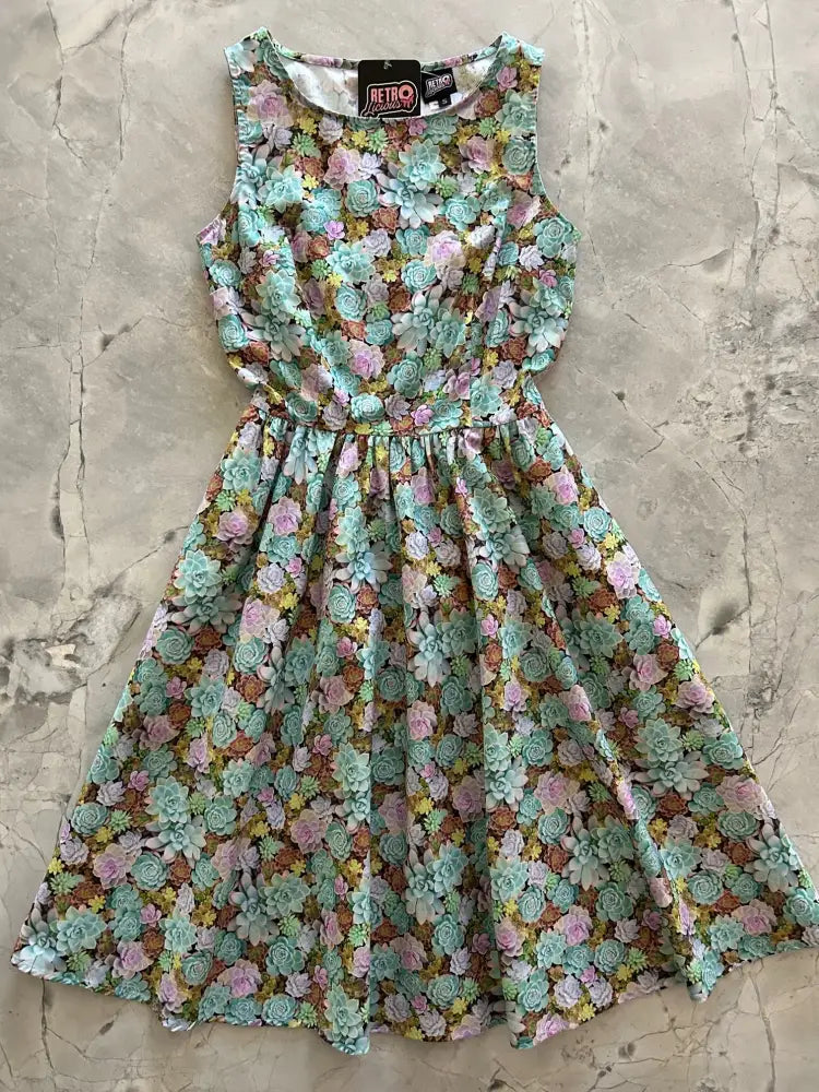 A sleeveless vintage 1950s mint green cotton a-line dress with a delicate pink yellow and brown floral pattern