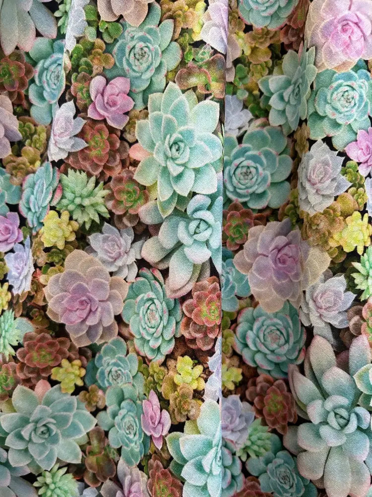 Vintage 1950s cotton a-line dress featuring a vibrant multicolored succulent print in mint green pink and pale yellow