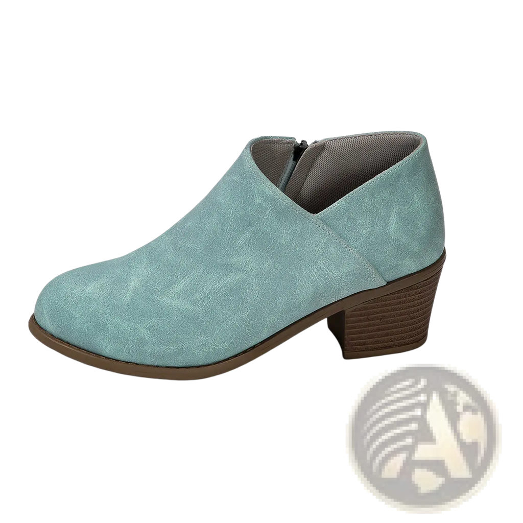 A mint green suede ankle boot with a chunky brown stacked heel and side zipper closure