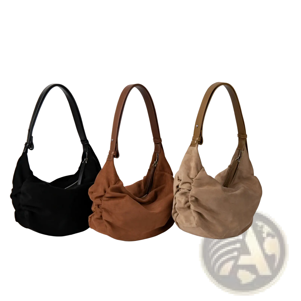 Three suede dumpling shoulder bags in black brown and tan with matching leather straps for slouchy crossbody use