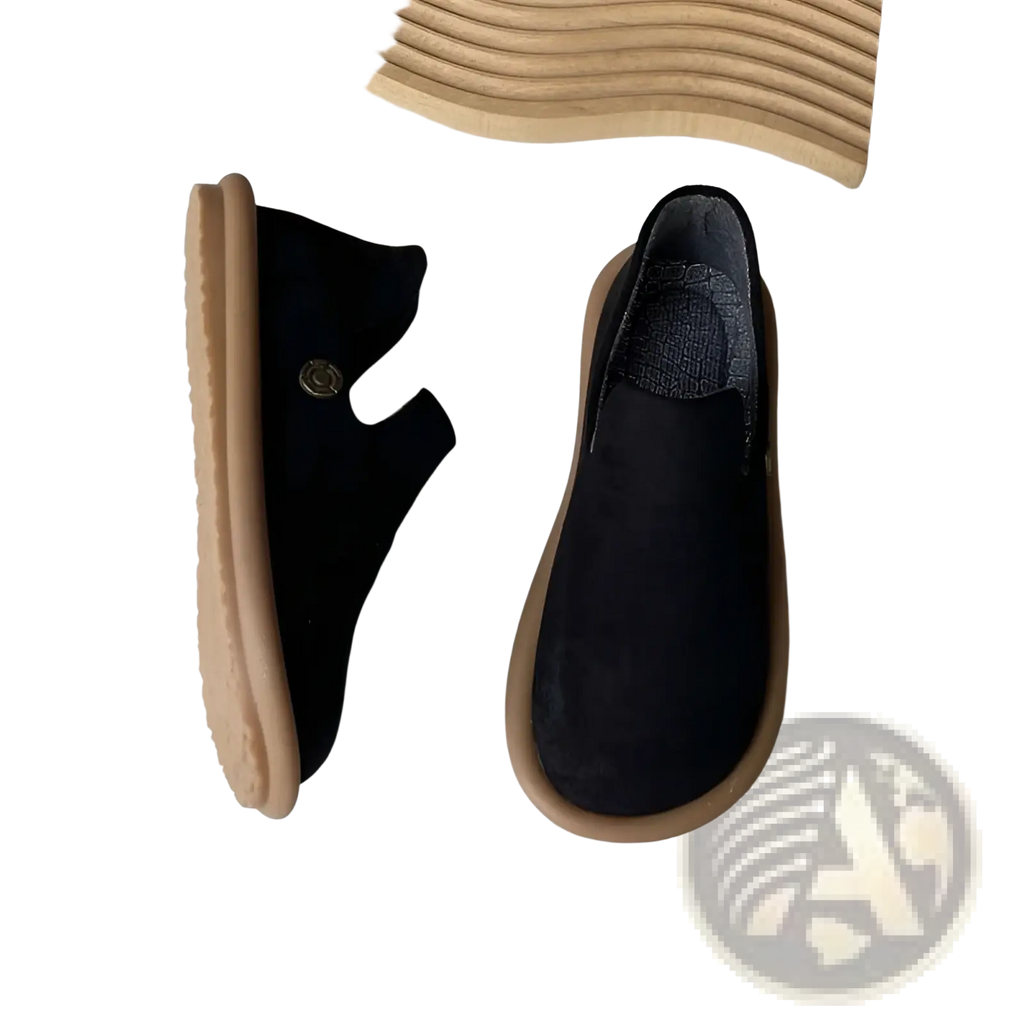 Black suede slip on vintage British style low heel pumps with tan rubber soles and a small metallic button on the side
