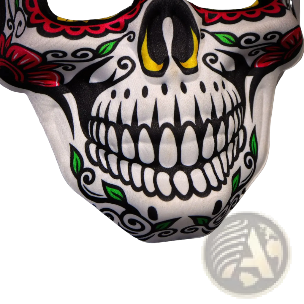 A white fabric sugar skull mask with vibrant red black and green floral patterns and yellow eye accents for Day of the Dead