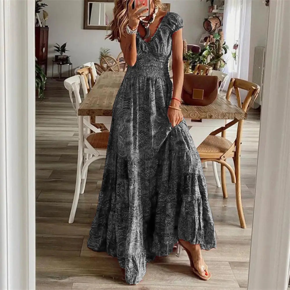 A flowing dark gray floral paisley v neck maxi dress with tiered ruffles and subtle pattern detail