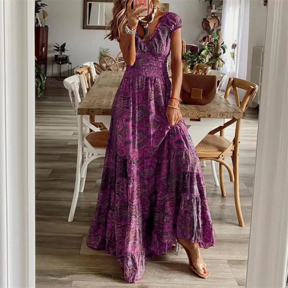 A flowing tiered maxi dress in vibrant purple with a subtle paisley pattern and ruffled hem floral paisley v neck design