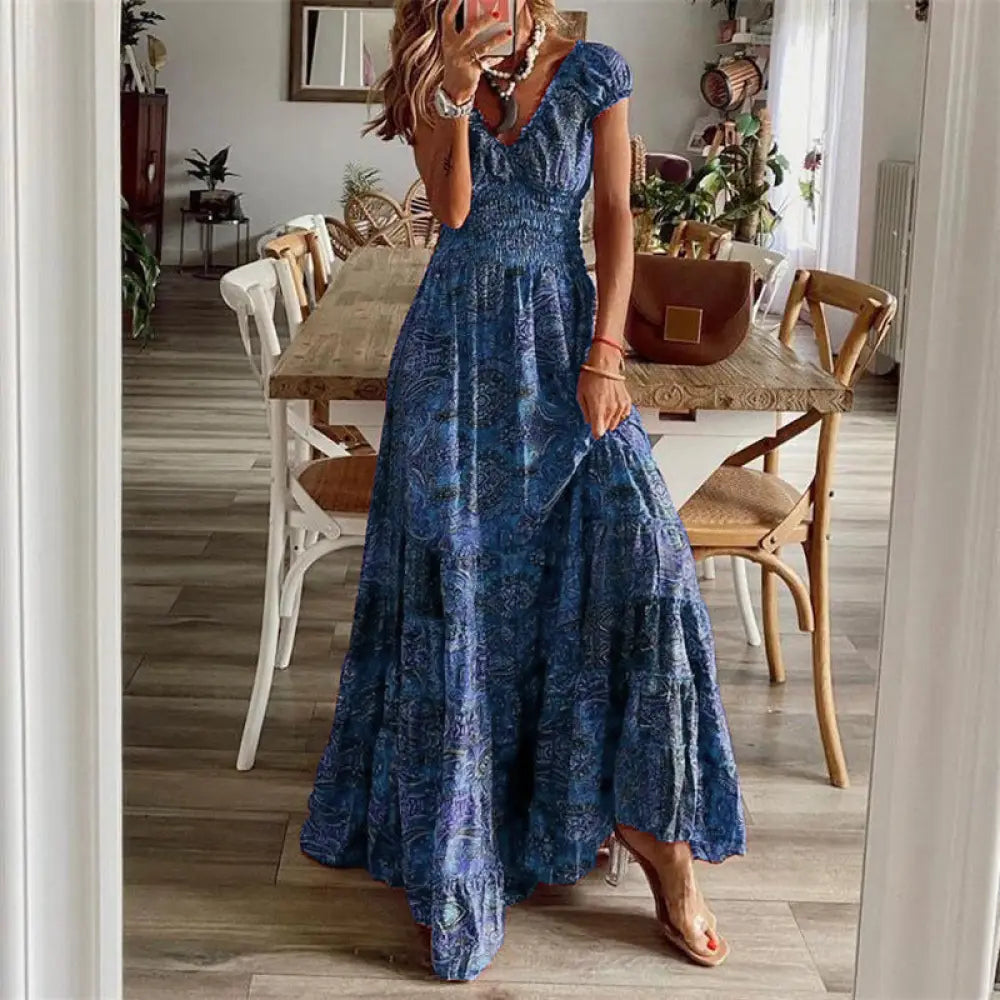 A flowing blue floral paisley maxi dress with v neckline and tiered skirt made from lightweight fabric