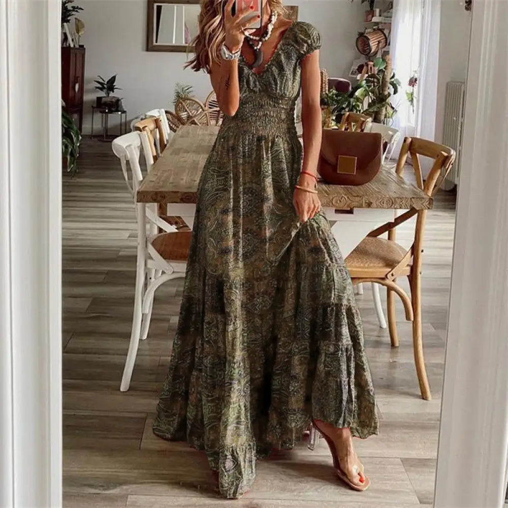 A flowing olive green maxi dress with a subtle paisley pattern and tiered ruffle hem for elegant occasions