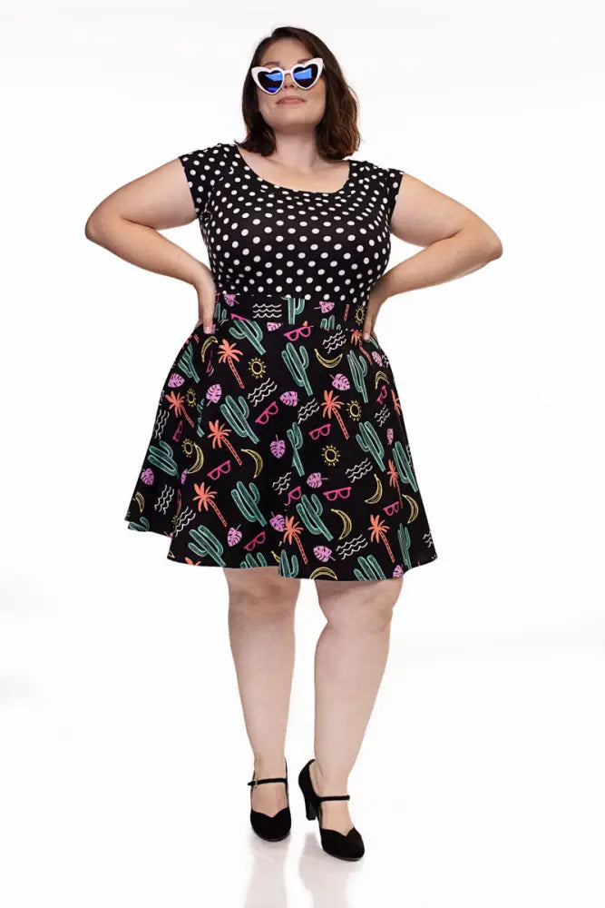 Black plus-size neon desert print retro skater skirt with polka dot top and colorful tropical motifs on flared skirt