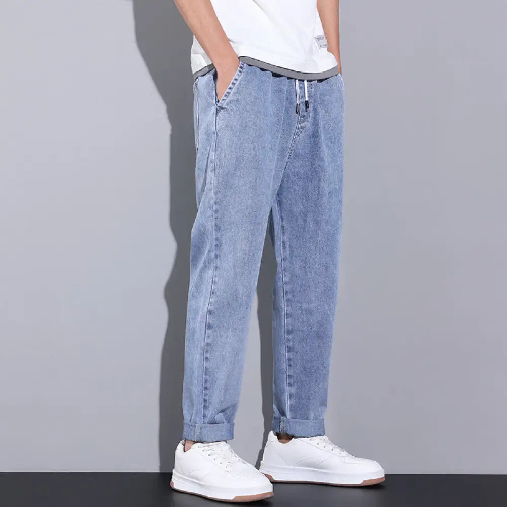 Men’s wide leg light wash denim joggers featuring a relaxed fit and rolled cuffs in light-wash denim