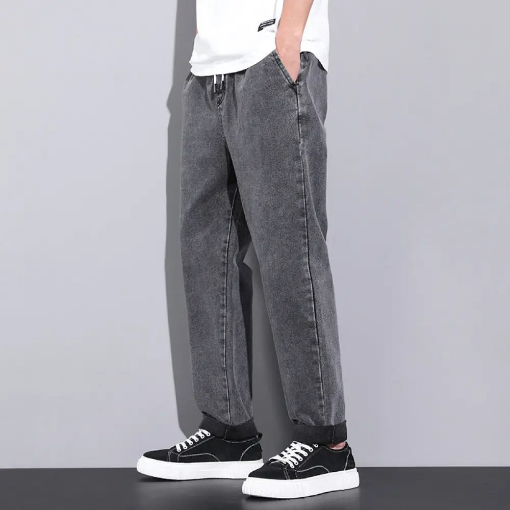 Men’s wide leg light wash denim joggers in dark gray faded denim with relaxed fit and rolled cuffs
