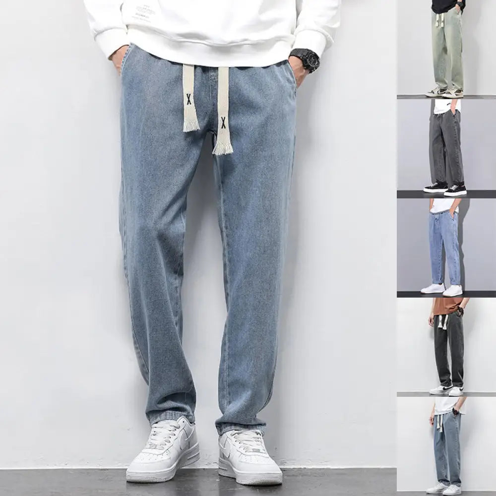 Men’s wide leg light wash denim joggers with white drawstring black x branding and frayed ends visible on front side