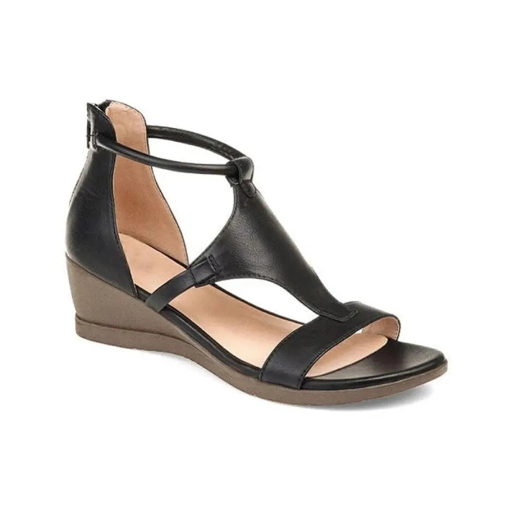 Women’s black leather wedge sandal with t-strap and ankle strap designed for summer wear