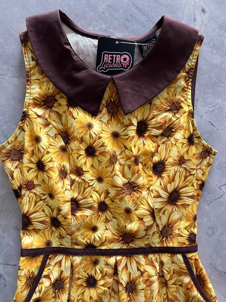 Retro sunflower cotton sleeveless dress with pockets featuring vibrant yellow sunflower print and dark brown satin trim