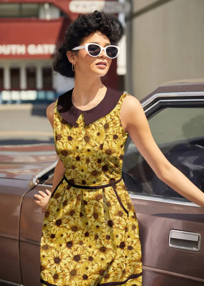 Yellow sunflower print cotton sleeveless dress with dark brown peter pan collar and matching belt with pockets