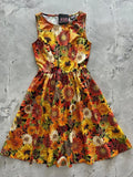 A vibrant sleeveless vintage sunflower autumn floral cotton a-line dress with yellow orange and red sunflowers on dark background