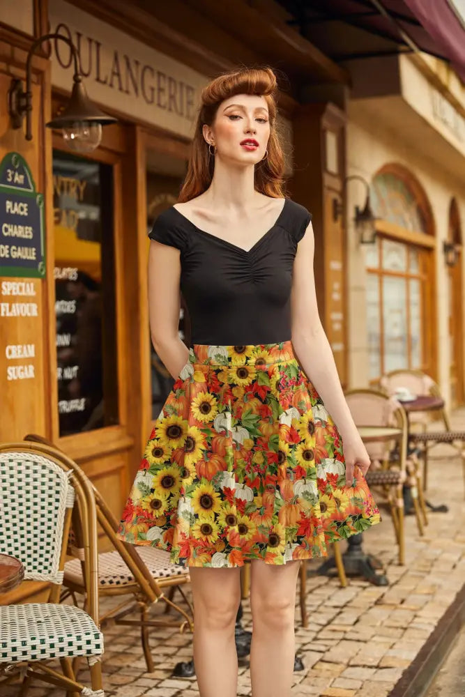 A vibrant sunflower and pumpkin autumn floral skater skirt with bold yellow, orange, and red leaf patterns