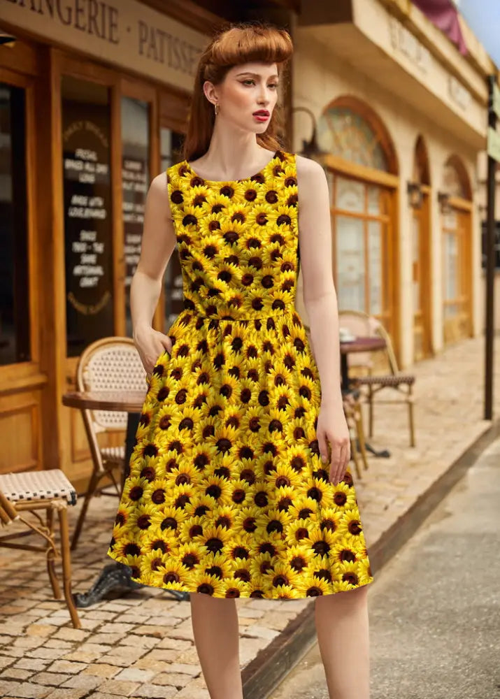 A vibrant yellow vintage sunflower print 1950s cotton midi dress with sleeveless fitted bodice and flared skirt