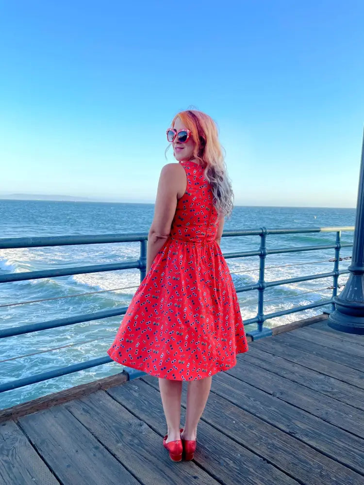 A vintage red floral sunglasses print cotton a-line dress with a vibrant sleeveless fitted bodice and flared skirt