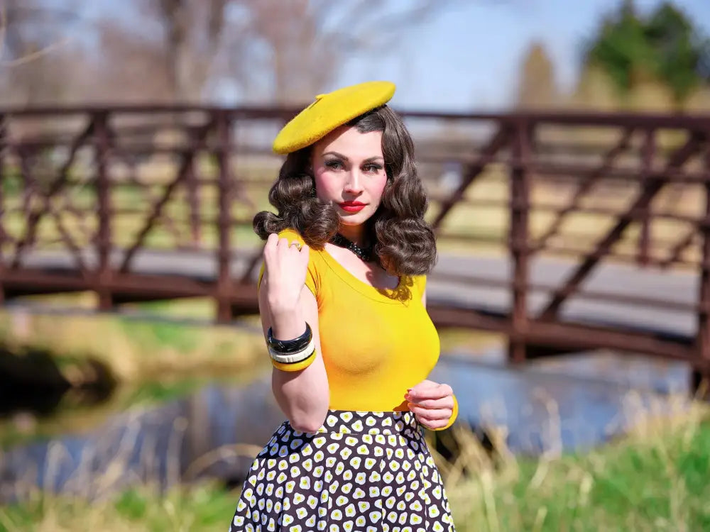 Yellow beret displayed alongside a sunny side up polka dot skater skirt in vibrant yellow fabric