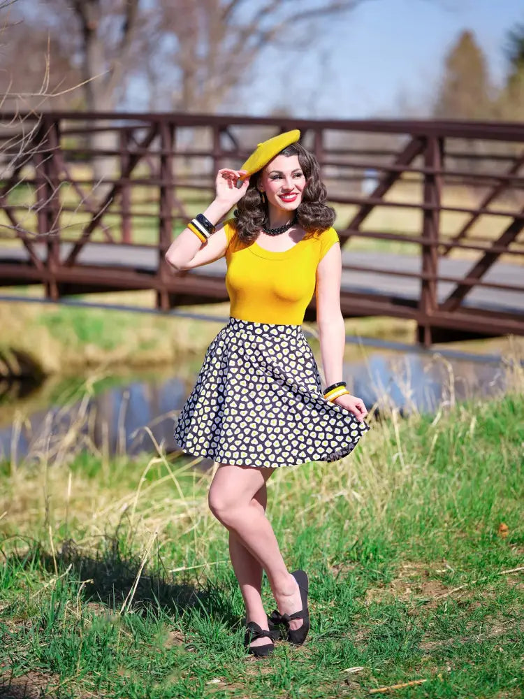 Yellow sleeveless top with fitted bodice and rounded neckline paired with sunny side up polka dot skater skirt