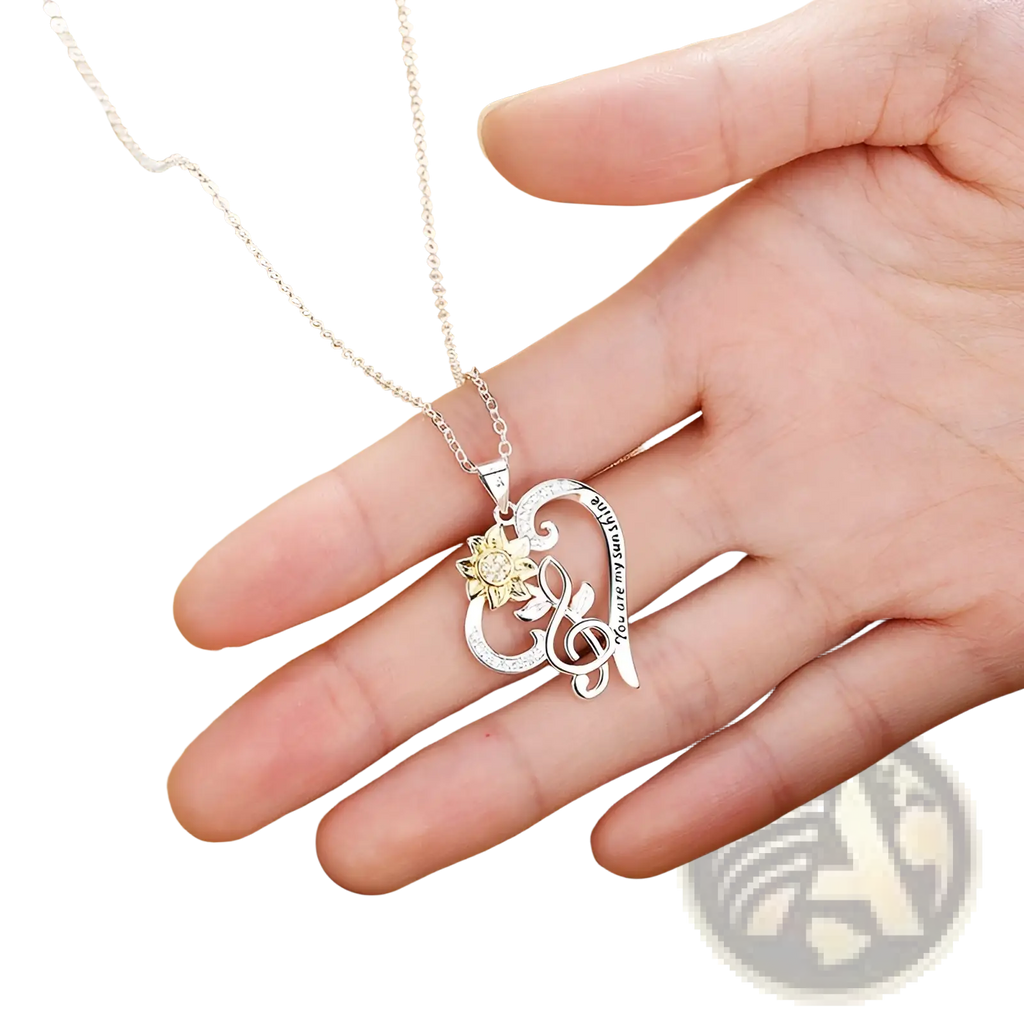 Silver heart-shaped pendant necklace with gold-toned sunflower musical note and engraved you are my sunshine text
