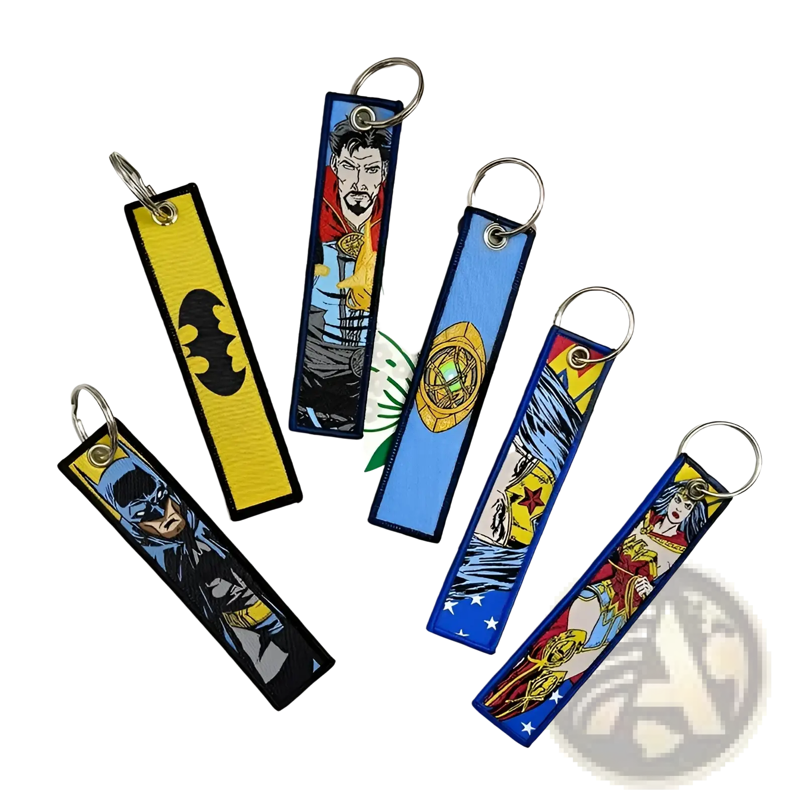A set of colorful embroidered superhero keychains on fabric tags with metal rings featuring batman and others