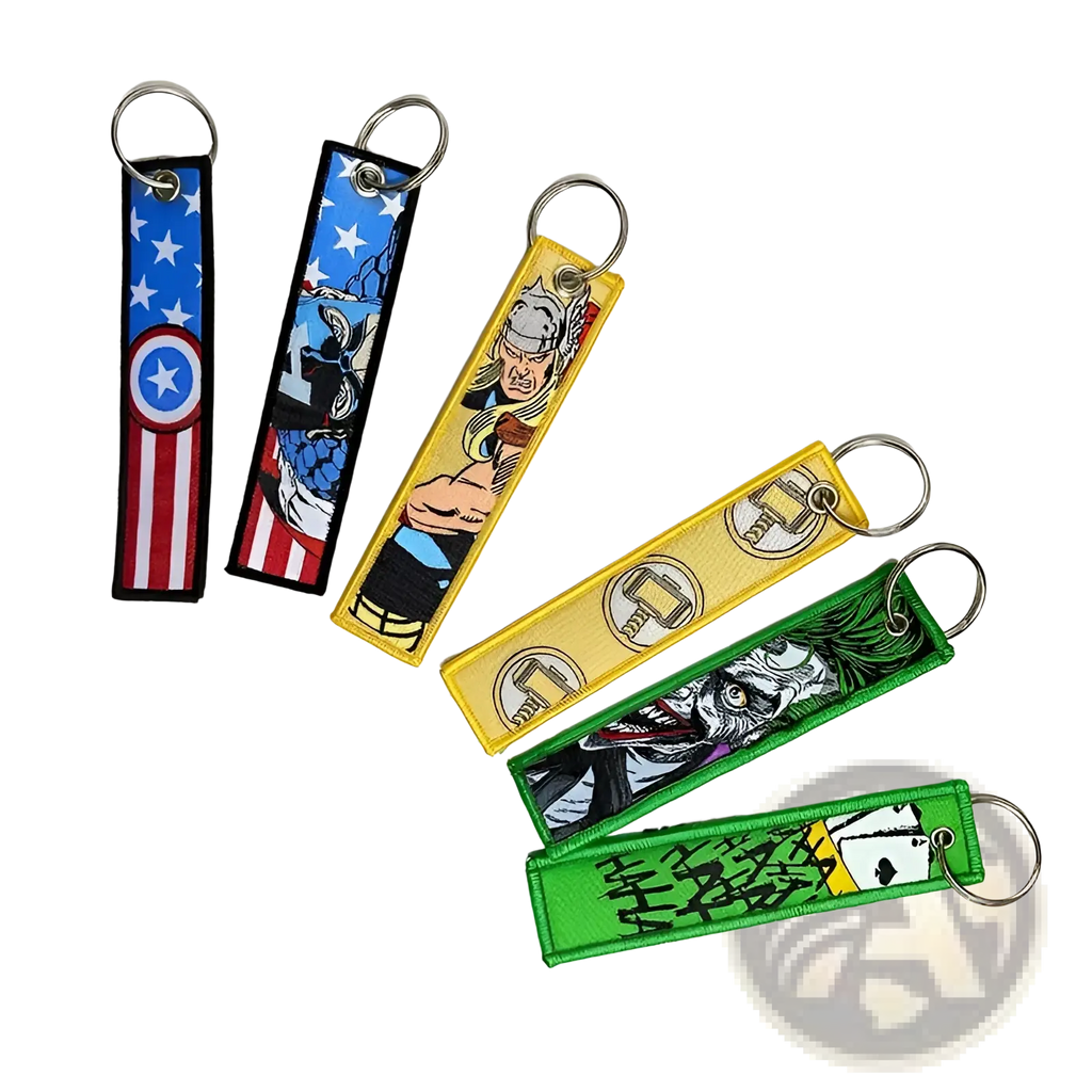 A set of colorful embroidered superhero keychains featuring Marvel and Joker designs with metal ring attachments