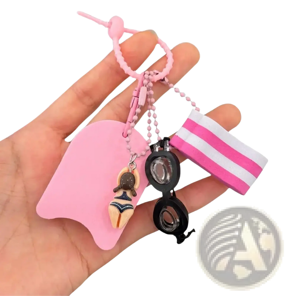 Pink silicone swim float keychain featuring miniature swimsuit figurine black goggles and striped pink white wristband charm