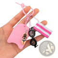 Pink silicone swim float keychain featuring miniature swimsuit figurine black goggles and striped pink white wristband charm