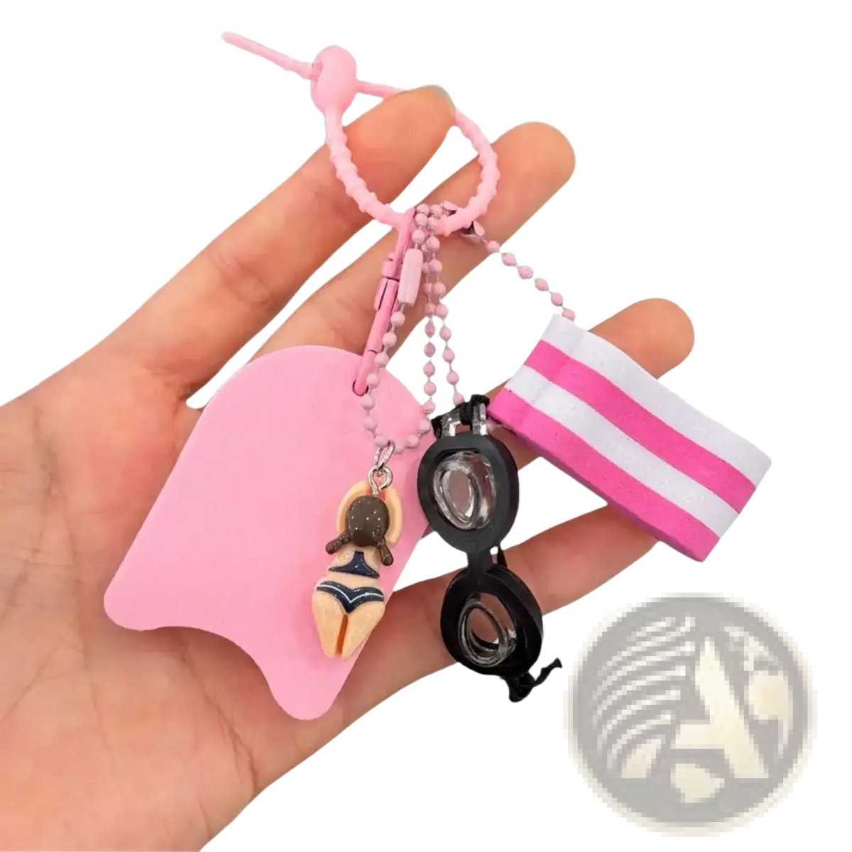 Pink silicone swim float keychain featuring miniature swimsuit figurine black goggles and striped pink white wristband charm