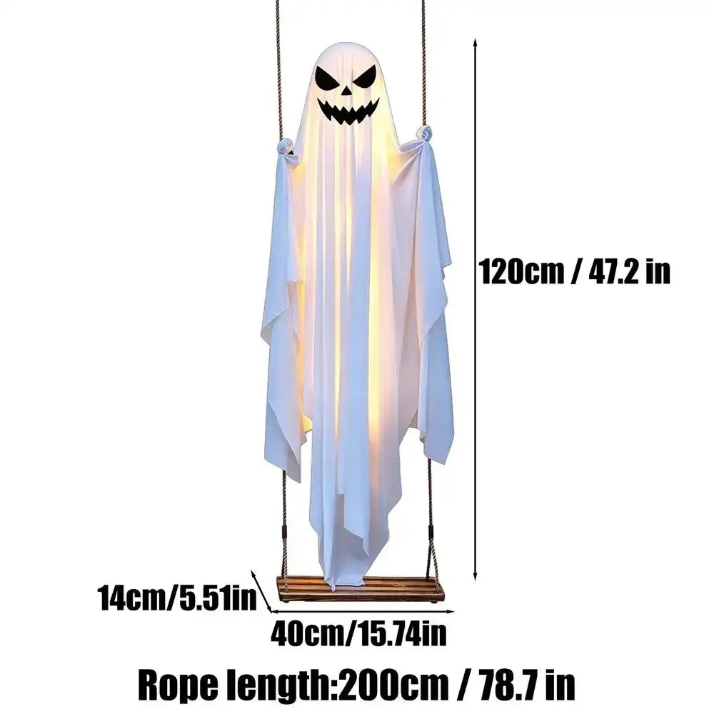 A glowing white swinging ghost halloween tree swing decoration with carved face hanging from wooden swing rope