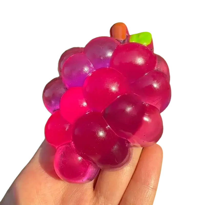 A translucent glossy pink and purple grape-shaped stress ball held in hand for taba-licious fun fruit fidget toy