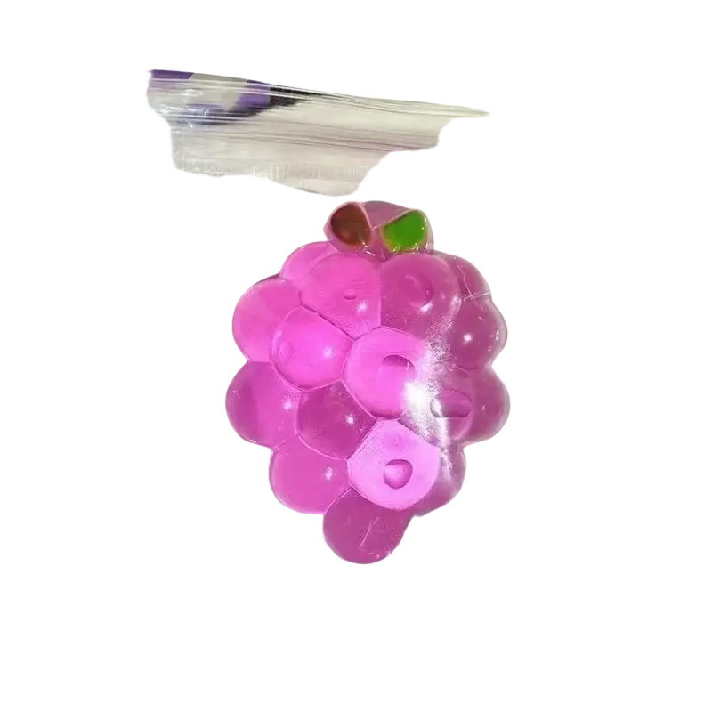 A translucent pink grape-shaped taba-licious fun fruit fidget toy with glossy finish and green leaf accents