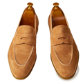 Tan suede penny loafers with white contrast stitching featuring classic design and gold-toned shoe trees
