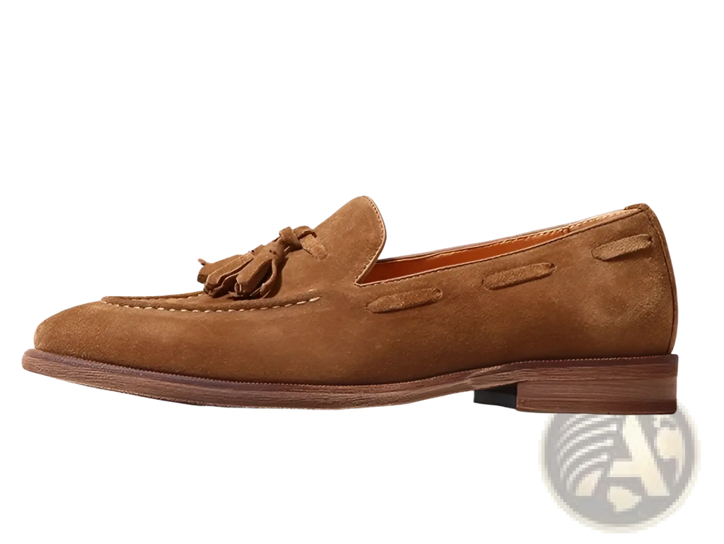 Tan suede tassel loafers with stitched leather accents and a stitched rubber sole for stylish comfort