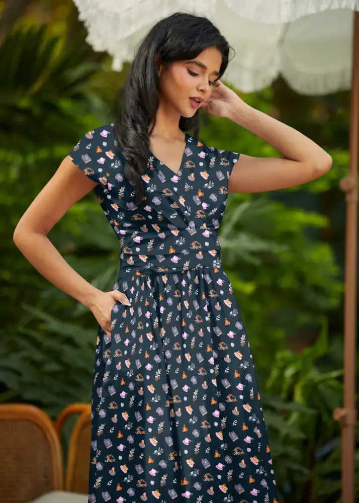 Greta tea party navy blue cotton wrap dress with pockets featuring a delicate pastel botanical and whimsical pattern