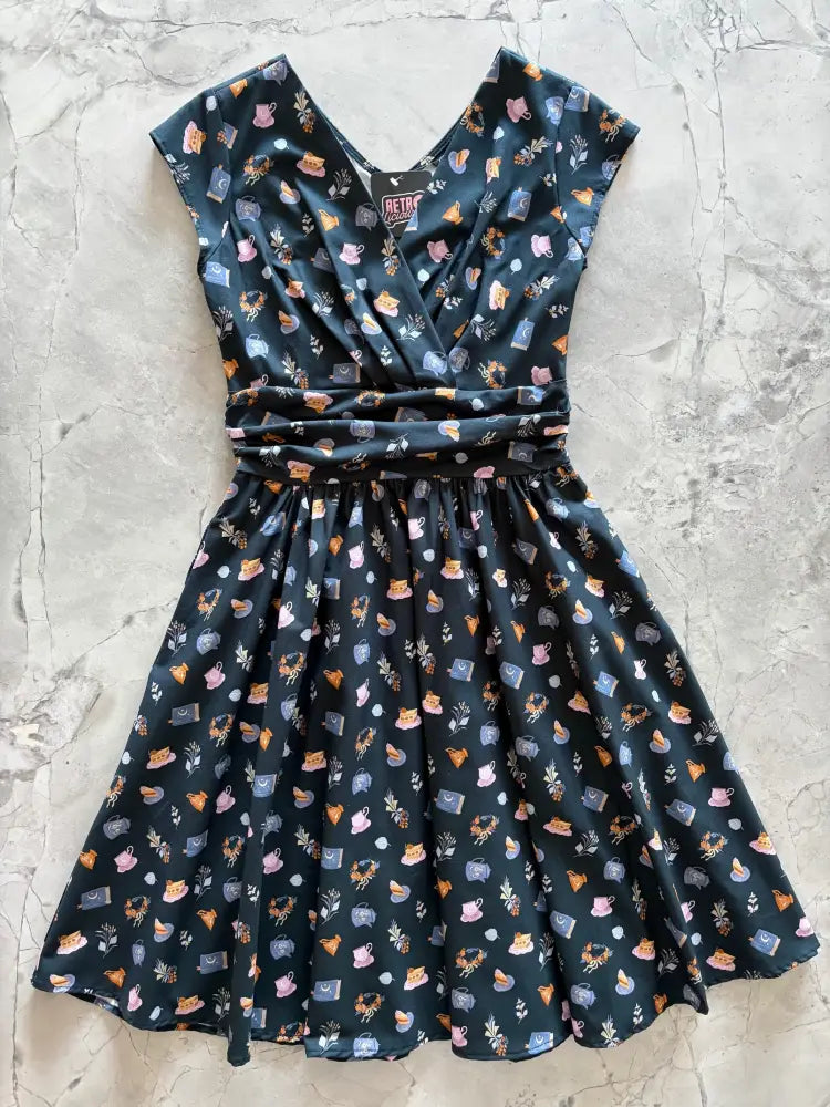 Greta tea party navy blue cotton wrap dress with pockets featuring v-neck short sleeves and pastel teacup and book print
