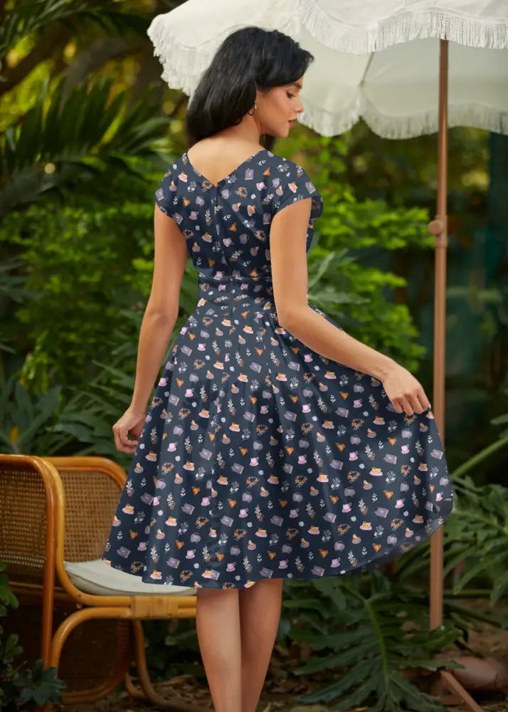 Greta tea party navy blue cotton wrap dress with pockets featuring a fitted bodice and pastel teacup pattern