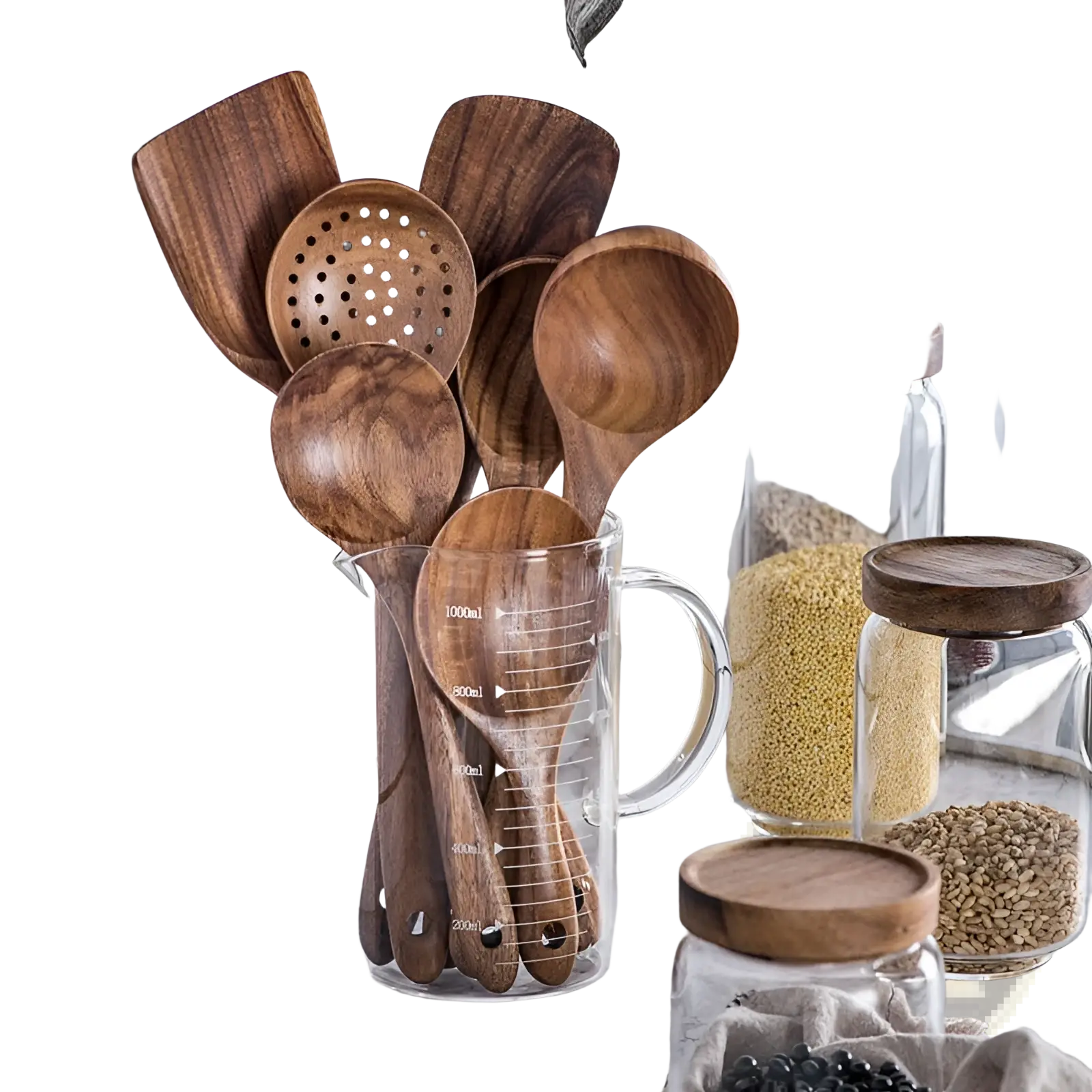 Set of four teak wood cooking utensils with natural wood grain and rounded handles in a clear glass measuring cup