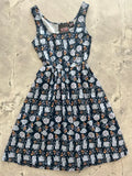 Navy blue sleeveless cotton fit and flare midi dress with white teapots and orange floral pattern and fitted bodice