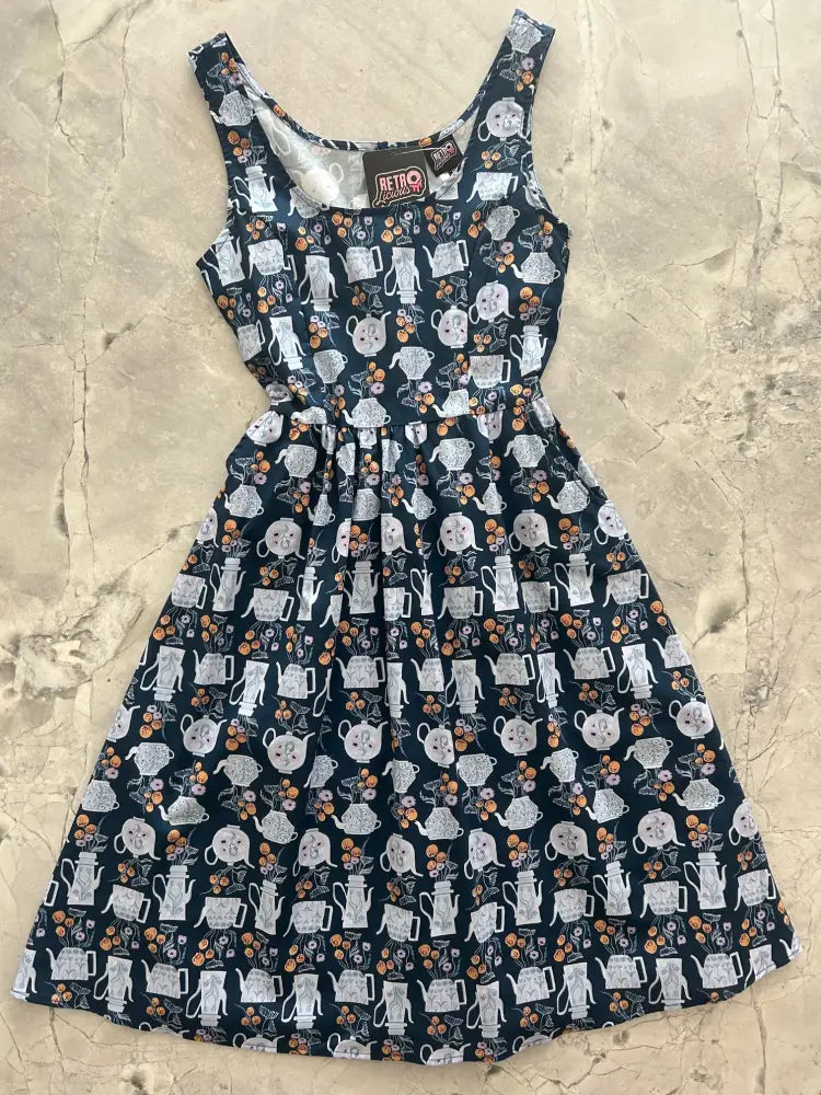 Navy blue sleeveless cotton fit and flare midi dress with white teapots and orange floral pattern and fitted bodice