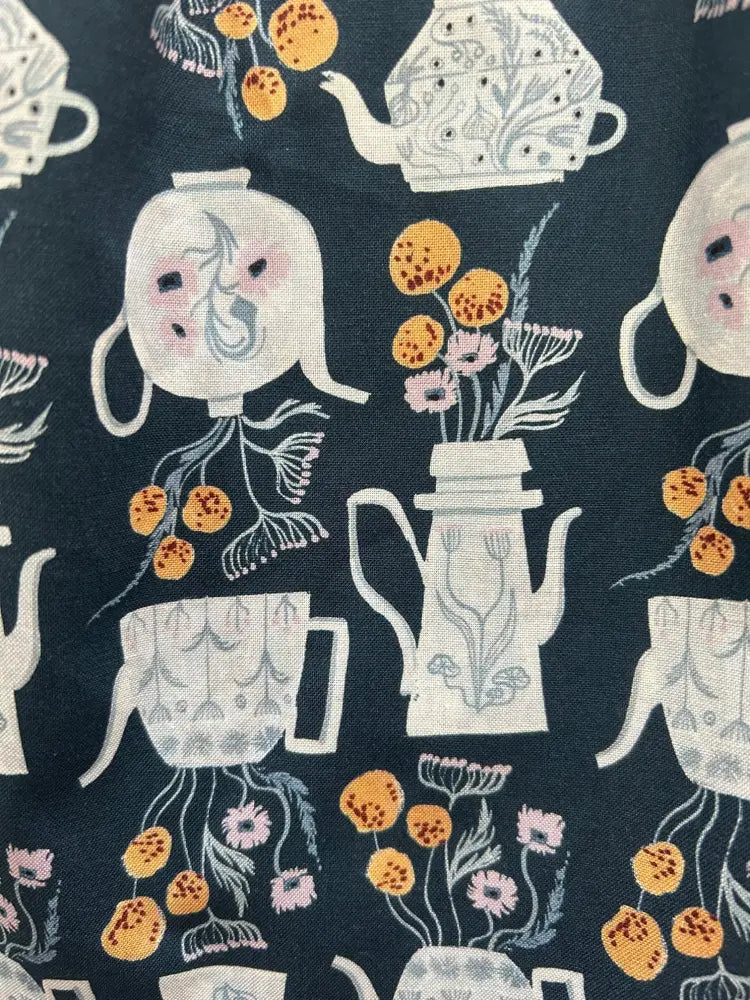 Dark blue cotton fit and flare midi dress with whimsical white teapots coffee pots and orange pink floral pattern
