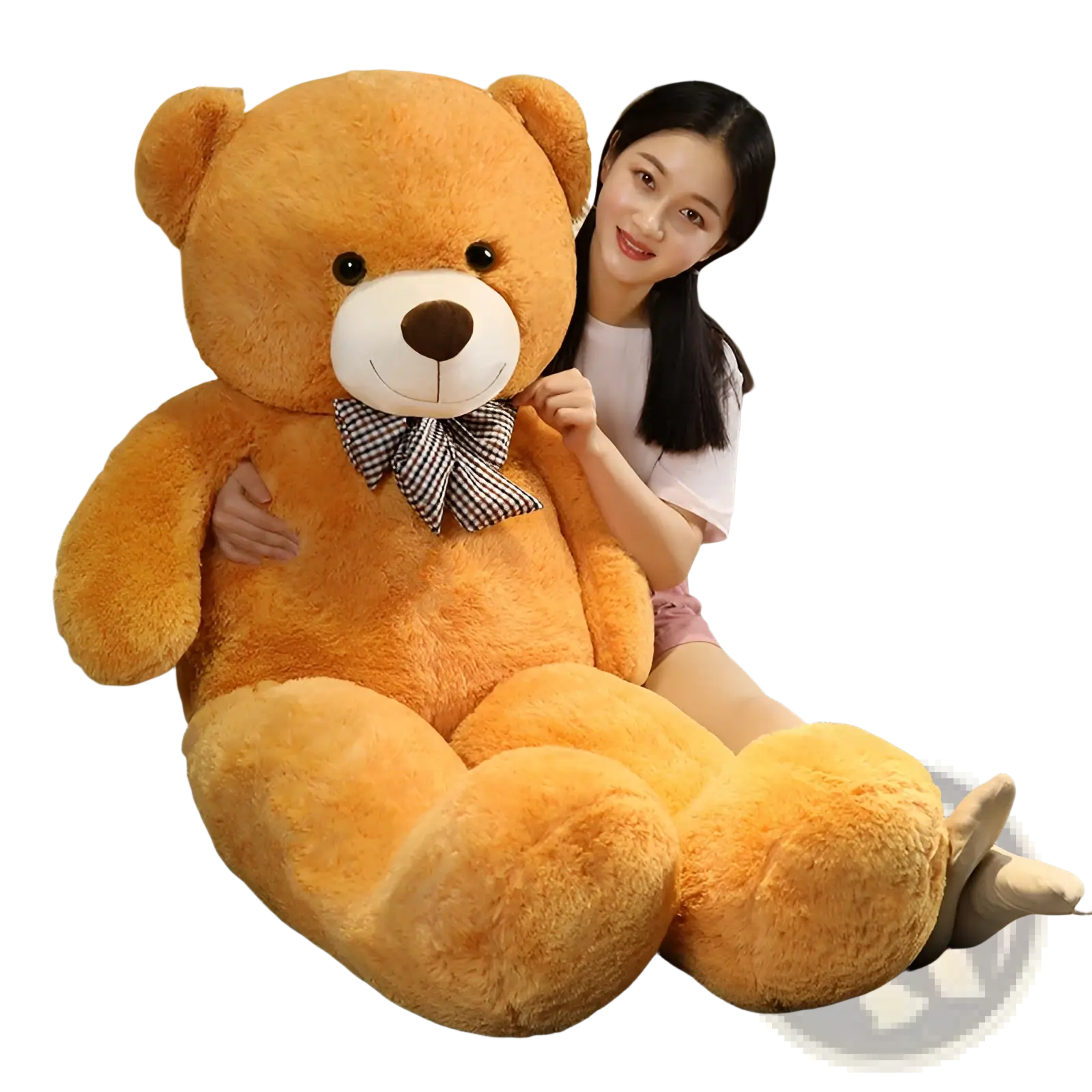 Teddy bear plush toy in golden brown with a white snout and black button eyes wearing a checkered bow tie