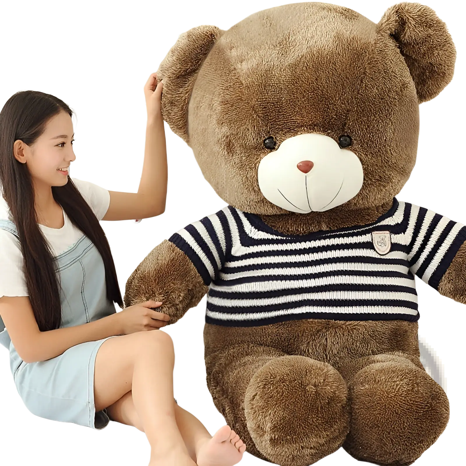 A plush brown teddy bear wearing a navy and white striped knit sweater with an embroidered chest patch