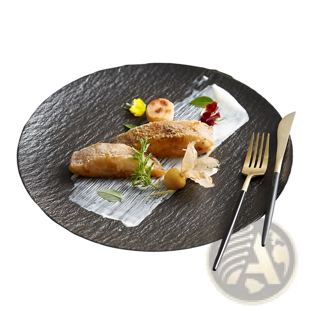 Black textured ceramic round plate with nordic rock pattern featuring an elegant serving of seared fish garnished with herbs and flowers