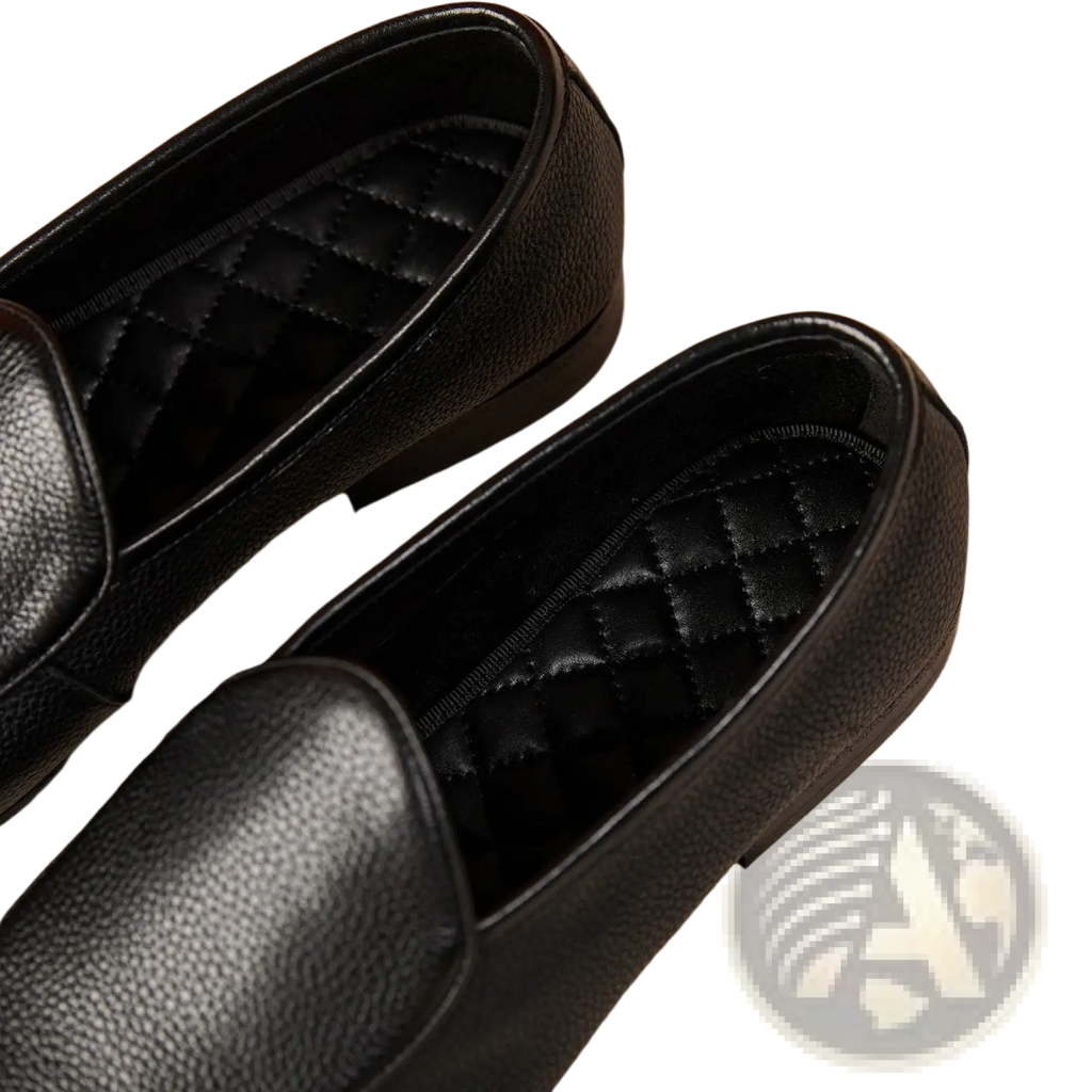 Black leather loafers with textured cowhide surface and quilted lining featuring a pointed toe design